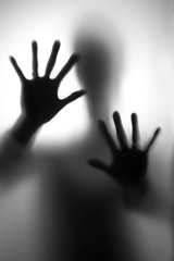 Person in fear - Silhouette of a woman, defending her self with here hands.