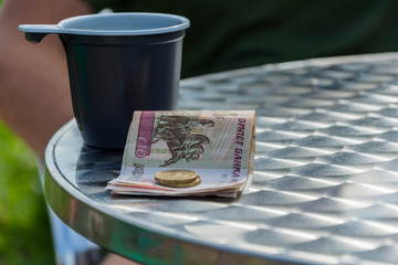 Money and the plastic mug on the edge of the table.