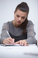 business woman writing in a notepad in the office