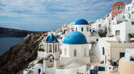 A blue-domed Greek Orthodox church overlooking the Aegean Sea in Oia town on the island of Santorini, Greece