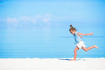 Adorable little girl have fun on tropical white sandy beach