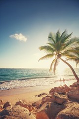 Sunrise over exotic island. Two girls walking on the beach.