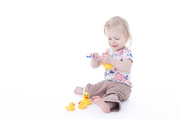 toddler girl brushing duck teeth