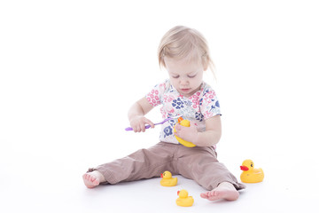 toddler girl brushing duck teeth