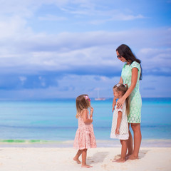 Fototapeta premium Young mother and her little daughters enjoy summer vacation
