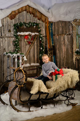 Boy sitting on a Christmas sleigh