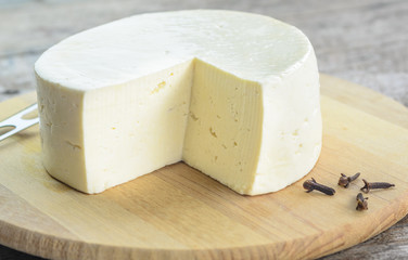 White cheese on a tray on a wooden background