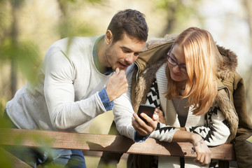 Happy Couple Using Phone Outdoor