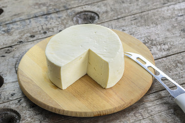 White cheese on a tray on a wooden background