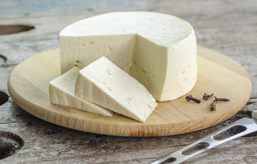 White cheese on a tray on a wooden background