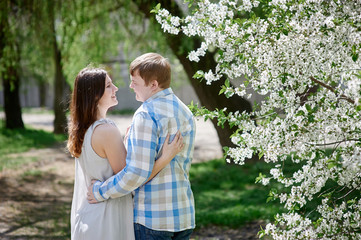 Fototapeta premium young couple in love walking in the blossom spring garden