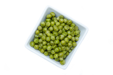Cooked peas on square bowl on a white background seen from above