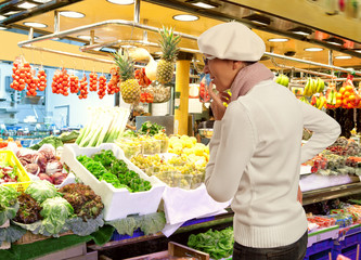 Woman buys fresh fruits and vegetables in market