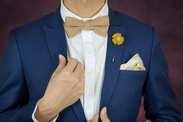 man in blue suit bowtie, brooch, handkerchief