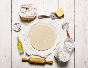 Roll out the pizza dough and ingredients - flour, cheese, olivkovoe oil.