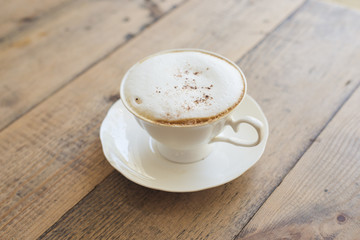 Hot cappuccino on wood background