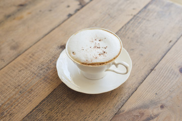 Hot cappuccino on wood background