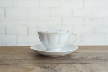 Hot cappuccino on wood background