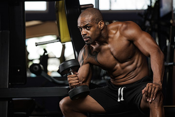 Fototapeta na wymiar oung adult bodybuilder doing weight lifting in gym.