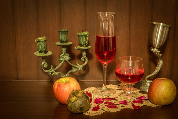 Still life image of red wine and fruits over wooden background
