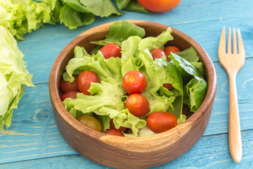 healthy salad with tomatoes on wooden table