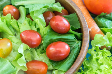 Closeup healthy salad with tomatoes on wooden table