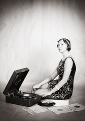 Girl listening to music on the gramophone. Retro