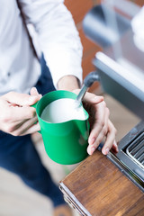 Close-up of man's hands holding pitcher with milk