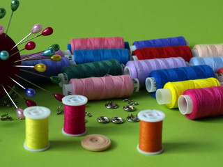 Разноцветные нитки катушки, иголки, лента сантиметровая, пуговицы  для кройки и шитья
