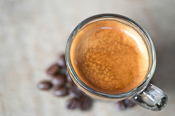 Shot of Espresso with beans on wood