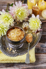 Bowl of yellow sea salt and dahlia flowers