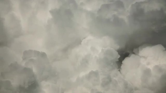 Curling puffy clouds of sunlit lumpy steam. Meditative view of calm and relaxing swirling motion of white pure vapor. White and gray delicate wreathing background.