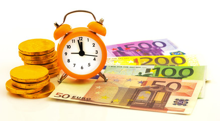 Alarm clock with paper euro money and gold coins
