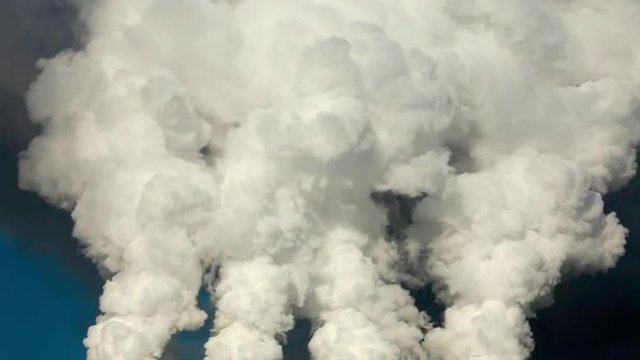 Dramatic view of of four smoke or steam columns with total clouds above. Dioxide carbon and warm, exhausting with the industry chimneys in the atmosphere, is the great danger for global ecology.