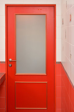 Red wooden door with glass in a bathroom