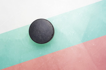 old hockey puck is on the ice with bulgaria flag