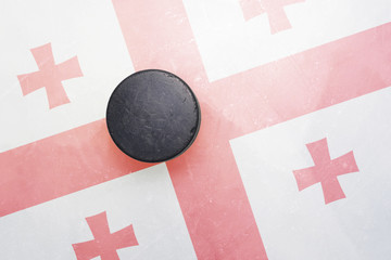 old hockey puck is on the ice with georgia flag