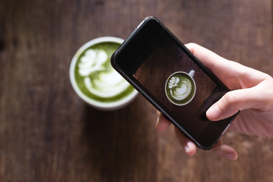 taking photo of green tea latte using smart phone