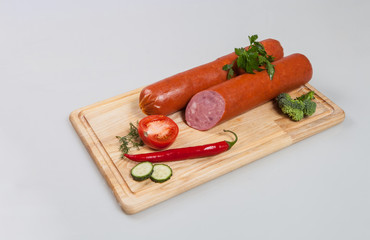 Sausage, parsley, pepper, onion, cucumber and cutting board on a white background in studio