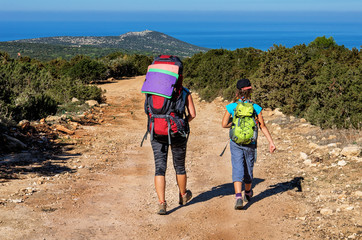 Fototapeta premium family with large backpacks are on road sea