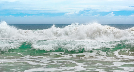 Big wave with sea foam and turquoise water.