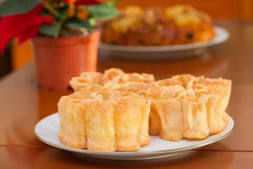 typical portuguese dessert filhos on white plate on brown background