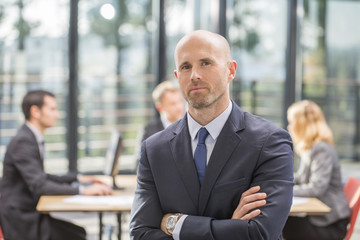 manager at the office with a group behind him