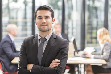 manager at the office with a group behind him