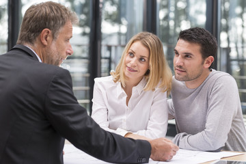 young couple meeting real estate agent for future house