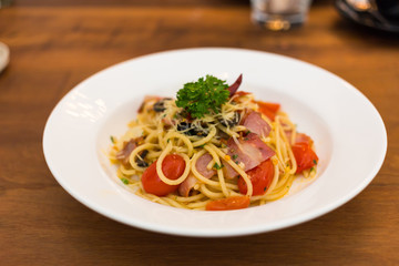 Spaghetti with bacon and dried chilli in white dish