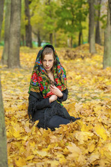 Young beautiful brunette woman posing outdoors in autumn park