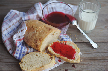 Bread with homemade jam in plate on wooden table, closeup