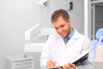 Dentist writes a patient a prescription in medical office