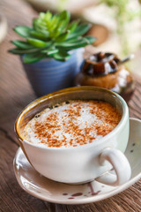 Cup of hot coffee on a wooden table.